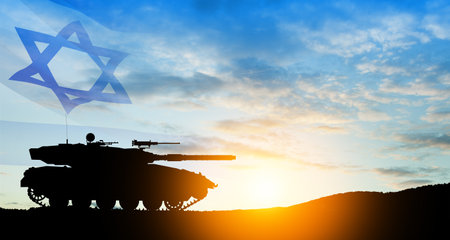 Silhouette of army tank at sunset sky background with Israel flag. Military machinery.の写真素材