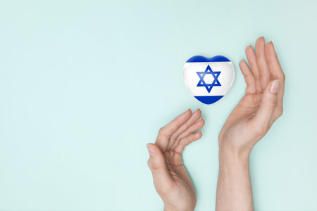 Heart with print of Israel flag in female hands. Flat lay.の写真素材