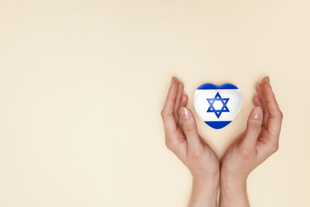 Heart with print of Israel flag in female hands. Flat lay.の写真素材