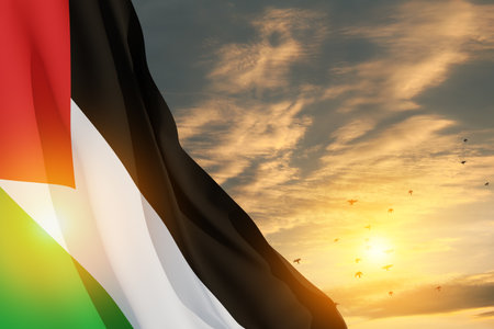 Palestine flag on background of sunset sky with flying birds. Banner with place for text.の写真素材