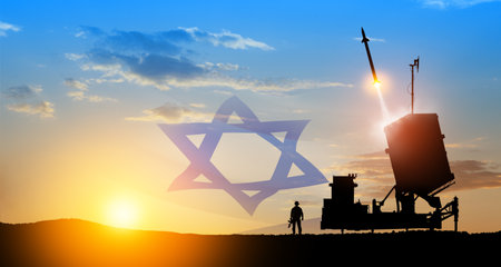 Israel's Iron Dome air defense missile launches. Silhouettes of soldier and Israel's Iron Dome air defense. The missiles are aimed at the sky at sunset with Israel flag. Missile defense.の写真素材