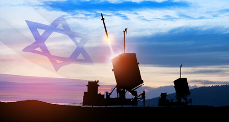 Israel's Iron Dome air defense missile launches. The missiles are aimed at the sky at sunset with Israel flag. Missile defense, a system of salvo fire.の写真素材