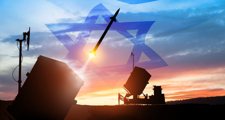 Closeup of Israel's Iron Dome air defense missile launches. The missiles are aimed at the sky at sunset with Israel flag. Missile defense, a system of salvo fire.の写真素材