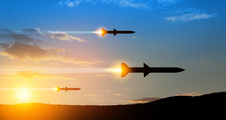 Fired missiles fly to the target. Missiles at the sky at sunset. Missile defense, a system of salvo fire.の写真素材
