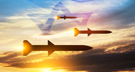 Fired missiles fly to the target. Missiles at the sky at sunset with Israel flag. Missile defense, a system of salvo fire.の写真素材