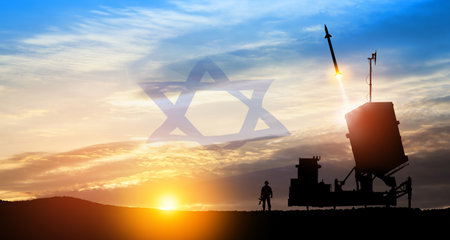 Israel's Iron Dome air defense missile launches. Silhouettes of soldier and Israel's Iron Dome air defense. The missiles are aimed at the sky at sunset with Israel flag. Missile defense.の写真素材