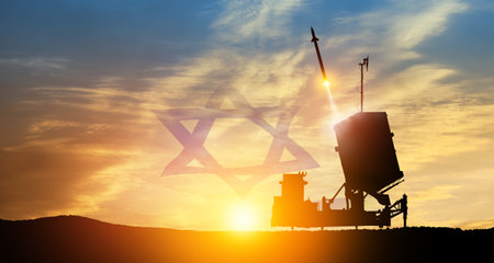 Israel's Iron Dome air defense missile launches. The missiles are aimed at the sky at sunset with Israel flag. Missile defense, a system of salvo fire.の写真素材
