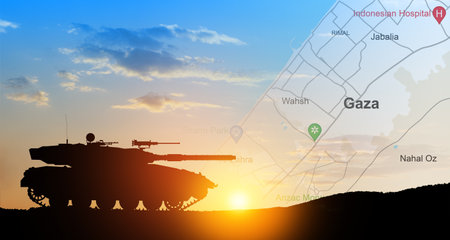 Silhouette of army tank at sunset sky background with map of Gaza. Israeli ground operation in Gaza.の写真素材