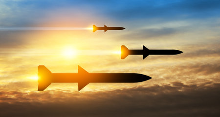 Fired missiles fly to the target. Missiles at the sky at sunset. Missile defense, a system of salvo fire.の写真素材