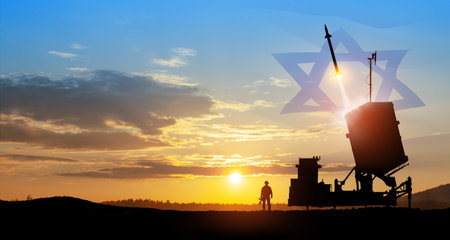 Israel's Iron Dome air defense missile launches. Silhouettes of soldier and Israel's Iron Dome air defense. The missiles are aimed at the sky at sunset with Israel flag. Missile defense.の写真素材