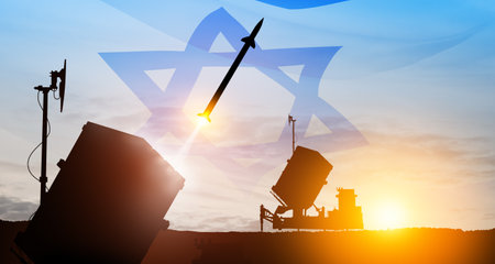 Closeup of Israel's Iron Dome air defense missile launches. The missiles are aimed at the sky at sunset with Israel flag. Missile defense, a system of salvo fire.の写真素材
