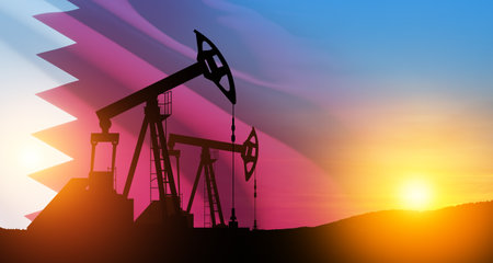 Oil drilling derricks at desert oilfield with Qatar flag. The change in oil prices caused by the war. Oil prices are rising because of the global crisis. Crude oil production from the ground.の写真素材
