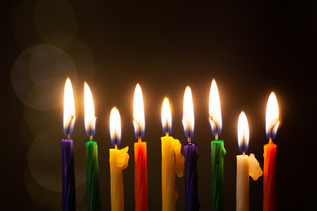 Closeup of Hanukkah menorah, or hanukkiah for Jewish holiday Hanukkah. Nine colored candles. Hanukkah lamp, nine-branched candelabrum.の写真素材
