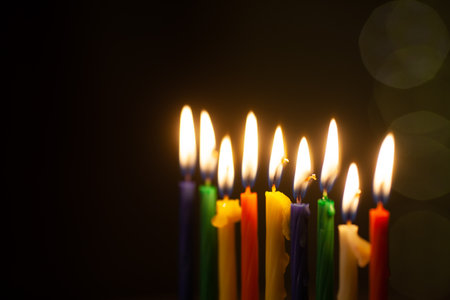 Closeup of Hanukkah menorah, or hanukkiah for Jewish holiday Hanukkah. Nine colored candles. Hanukkah lamp, nine-branched candelabrum. Selective focus.の写真素材