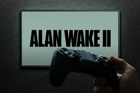 Alan Wake 2 game on TV screen with gamepad in hand on black textured wall with light. Astana, Kazakhstan - November 13, 2023.のeditorial素材