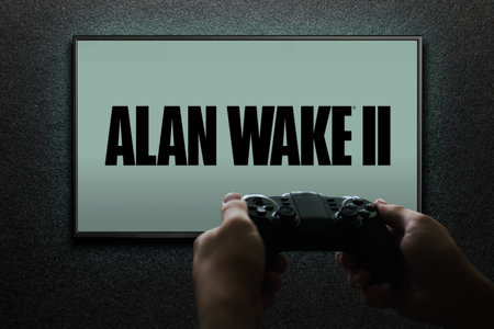 Alan Wake 2 game on TV screen with gamepad in hand on black textured wall with light. Astana, Kazakhstan - November 13, 2023.のeditorial素材