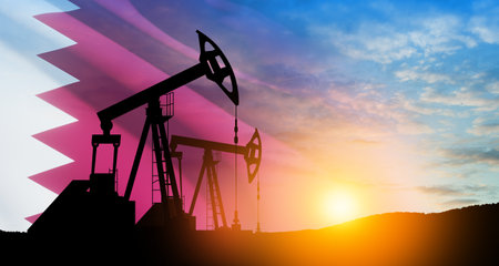 Oil drilling derricks at desert oilfield with Qatar flag. The change in oil prices caused by the war. Oil prices are rising because of the global crisis. Crude oil production from the ground.の写真素材