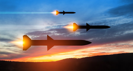 Fired missiles fly to the target. Missiles at the sky at sunset. Missile defense, a system of salvo fire.の写真素材