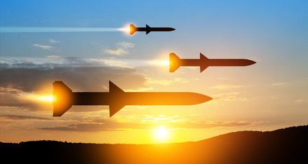 Fired missiles fly to the target. Missiles at the sky at sunset. Missile defense, a system of salvo fire.の写真素材