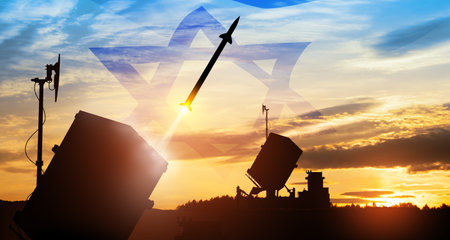 Closeup of Israel's Iron Dome air defense missile launches. The missiles are aimed at the sky at sunset with Israel flag. Missile defense, a system of salvo fire.の写真素材