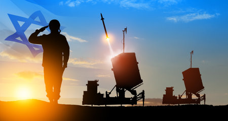 Israel's Iron Dome air defense missile launches. Silhouettes of soldier and Israel's Iron Dome air defense. The missiles are aimed at the sky at sunset with Israel flag. Missile defense.の写真素材