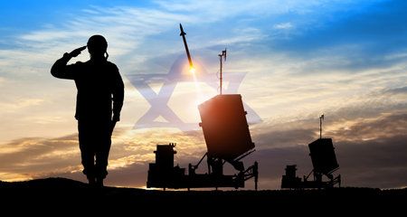 Israel's Iron Dome air defense missile launches. Silhouettes of soldier and Israel's Iron Dome air defense. The missiles are aimed at the sky at sunset with Israel flag. Missile defense.の写真素材