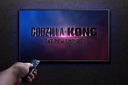 Godzilla x Kong The New Empire trailer or movie on TV screen. Man turns on TV with remote control. Astana, Kazakhstan - March 22, 2024.のeditorial素材