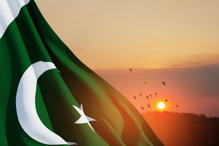 Pakistan flag on background of sunset sky with flying birds. Patriotic concept.の写真素材