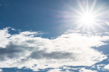 star of sun in blue sky and white clouds with space on left cornerの写真素材
