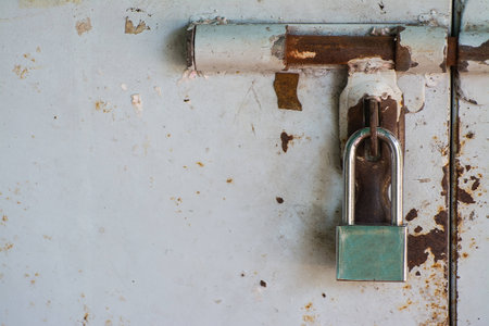 new padlock on old rusty white doorの写真素材