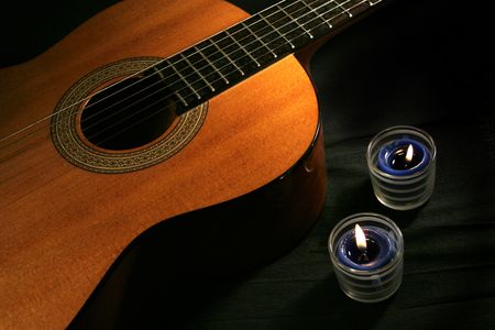 Classical guitar & candles on black backgroundの写真素材