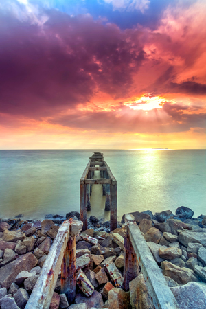 A long Exposure Picture Of abandoned old jetty with  burning sunset as backgroundの写真素材