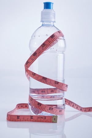 healthy eating, drinks, diet, detox and people concept - close up of tape with water in  bottleの写真素材