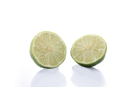 Green Lime with slice cutting isolated on white backgroundの写真素材