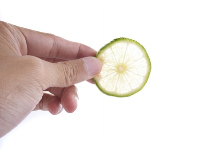 Green Lime with hand isolated on white backgroundの写真素材