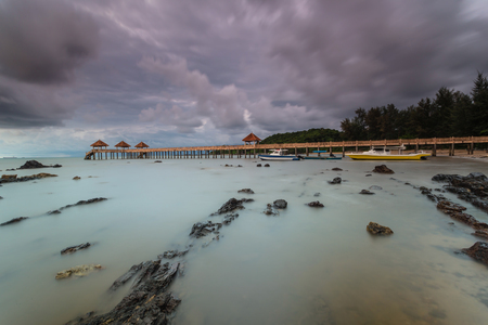Long exposure Cloudy sunrise shot at jetty. Image contain certain grain or noise and soft focus when view at full resolutionの写真素材
