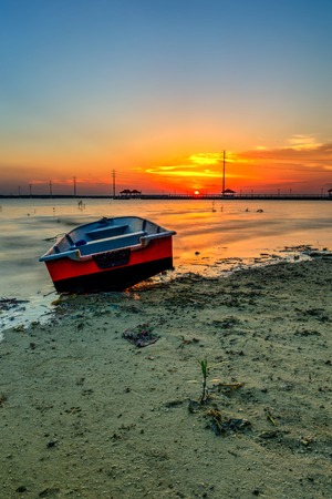 Beautiful A long exposure picture of sunset over a fishing boatの写真素材
