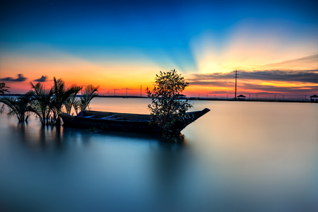 Beautiful A long exposure picture of sunset over a fishing boatの写真素材