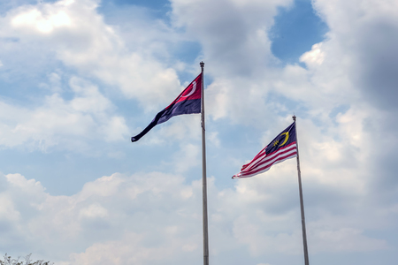 State flag of Malaysia And Johor bahru Flag.Malaysia flag also known as Jalur Gemilang wave with the blue sky. People fly the flag in conjunction with the Independence Day celebration or Merdeka Day.Johor Bahru is One of the states under the administration of malaysiaの写真素材