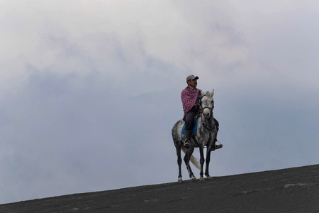 BROMO, INDONESIA - May 9 ,.2018. Unidentified local people or Bromo Horseman riding horse  at the mountainside of Mount Bromo, Semeru, Tengger National Park, Indonesia.のeditorial素材