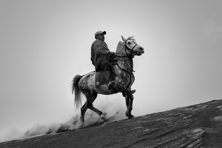BROMO, INDONESIA - May 9 ,.2018. Unidentified local people or Bromo Horseman riding horse  at the mountainside of Mount Bromo, Semeru, Tengger National Park, Indonesia.のeditorial素材