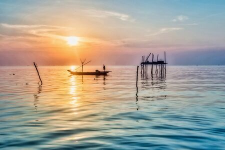 Beautiful view on sunrise with wooden boat as a subject at Kenjeran beach,Surabaya.Indonesiaの写真素材