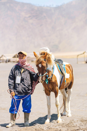 BROMO, INDONESIA - 18th September 2018; unidentified local people or Bromo Horseman pose for camera at the mountainside of Mount Bromo, Semeru, Tengger National Park, Indonesiaのeditorial素材