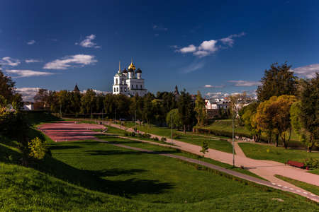 View of the Pskov Kremlin over the bridge at the city river on a summer clear day. The blue bright sky with clouds is reflected in a smooth surface of water.の写真素材