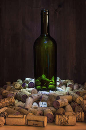Wine bottle without a drink on the background of the texture of wooden boards surrounded by a large...