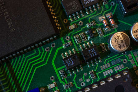 Macro close-up shot of green circuit board, computer motherboard Components: microcircuits, processor, transistors, semiconductors. Inside an electronic device, parts of a supercomputer.の写真素材