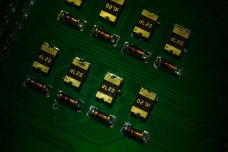 Macro close-up shot of green circuit board, computer motherboard Components: microcircuits, processor, transistors, semiconductors. Inside an electronic device, parts of a supercomputer.の写真素材
