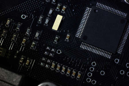Black motherboard (PCB) digital chip. Technical science background. Integrated communication processor. Information and engineering component. Programming and technologyの写真素材
