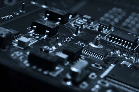 Fragment and components of a motherboard (PCB) of computer technology with many elements. Macro photography of processors and transistors. IT industry backgroundの写真素材