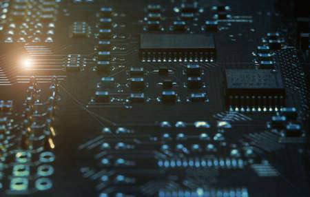 Fragment and components of a motherboard (PCB) of computer technology with many elements. Macro photography of processors and transistors. IT industry backgroundの写真素材